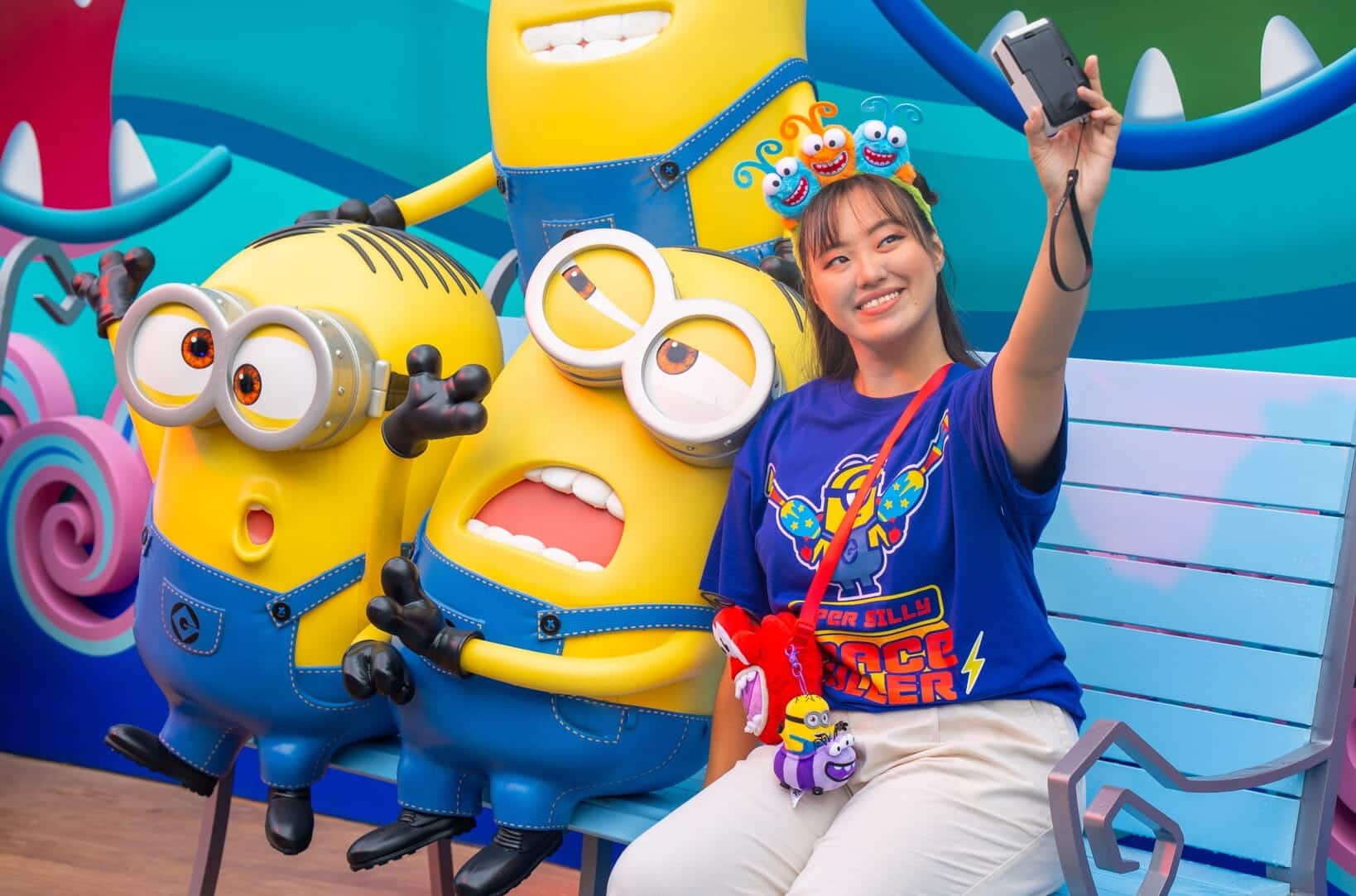 Guest posing for a photo with Minions in Minion Land at Universal Studios Singapore - header crop