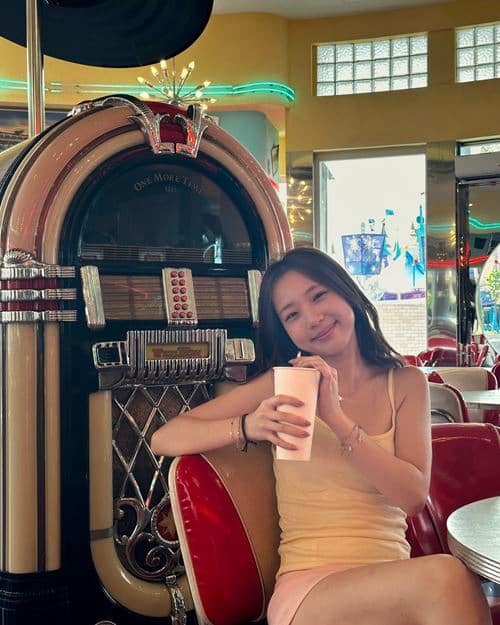 Guest enjoying a drink and posing in front of the jukebox at Mel's Diner in Universal Studios Singapore
