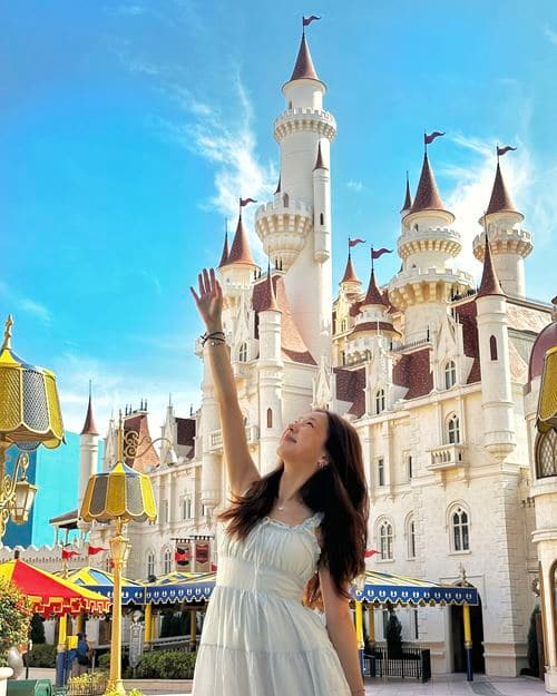 Guest posing for a photo in front of Far Far Away castle in Universal Studios Singapore