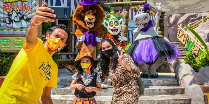 Family taking a photo with Madagascar mascots at USS
