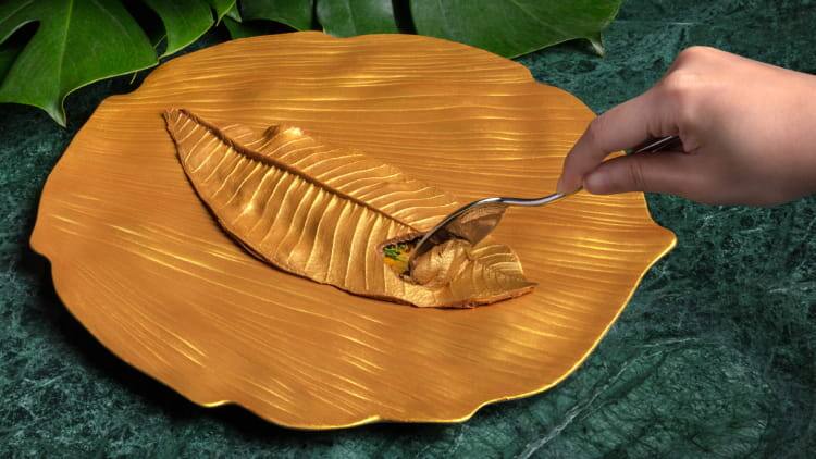 An elegantly plated golden chocolate leaf by table65